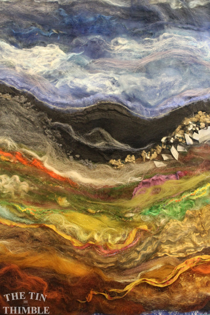 A colorful landscape scene with lots of fibers ready to be wet felted.